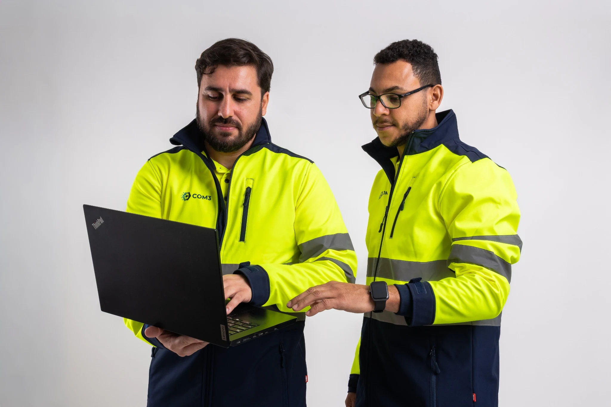 COM3 professionals working together with a laptop